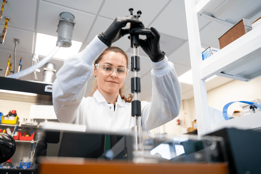 A researcher adjust equipment in an energy research lab at Tufts University.